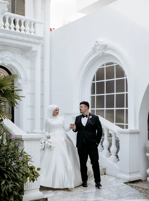 Beyaz mermer merdivenden inen gelin ve damat